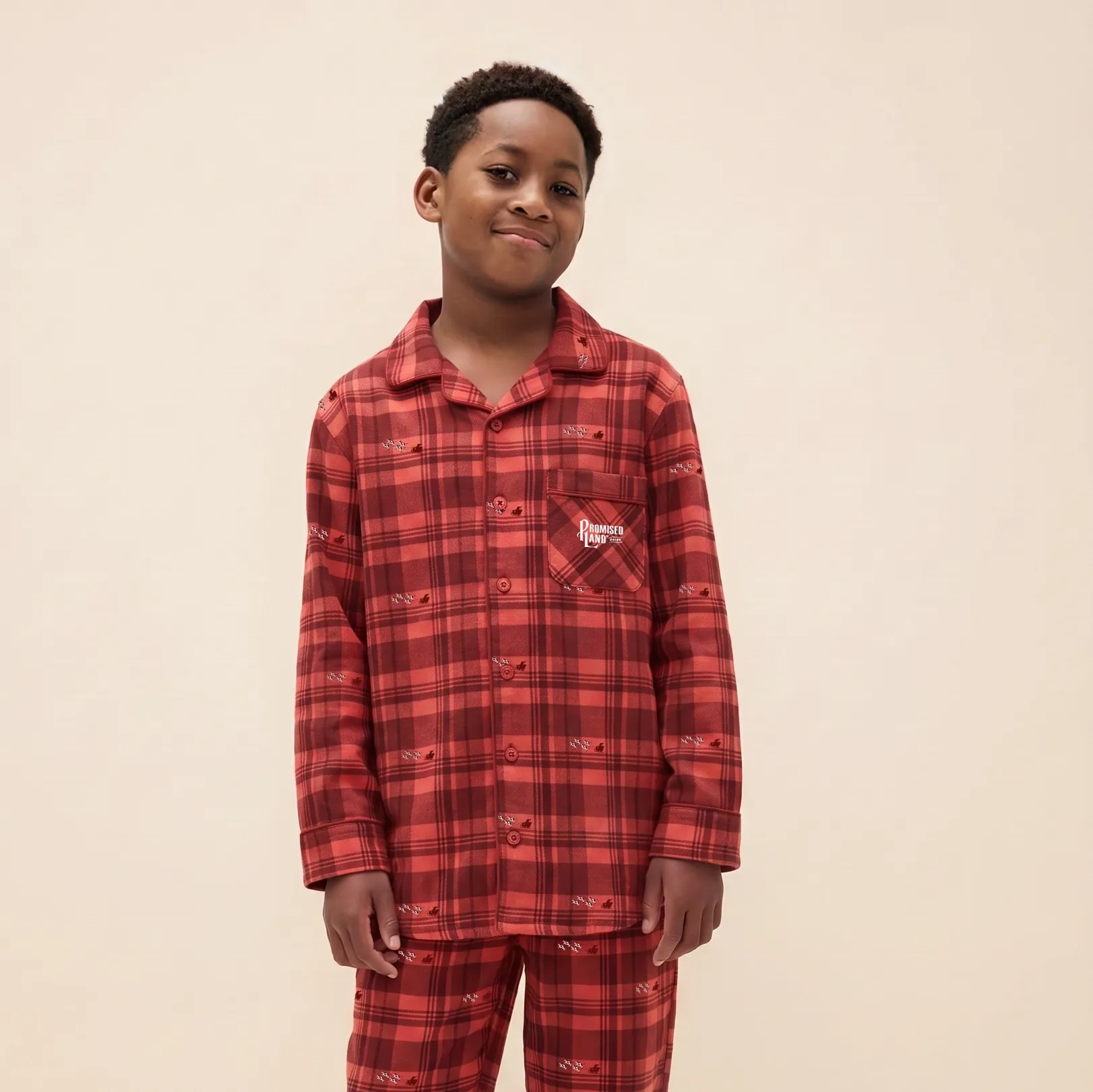 Boy in red plaid Promised Land Dairy pajamas with the logo on the pocket